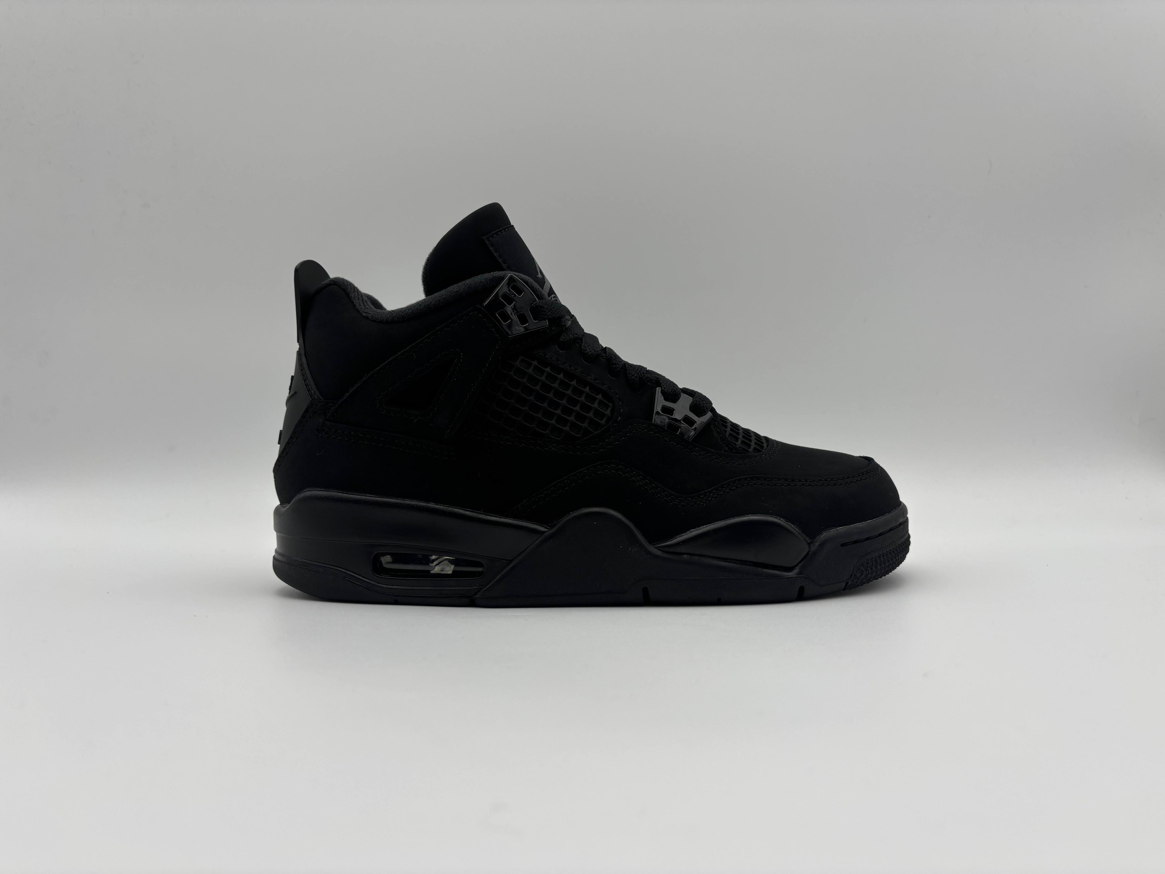 Side view of Air Jordan 4 Retro Black Cat 2025 GS sneakers with iconic high-top design, all-black nubuck upper, mesh paneling, and visible Air cushioning for basketball performance and streetwear style