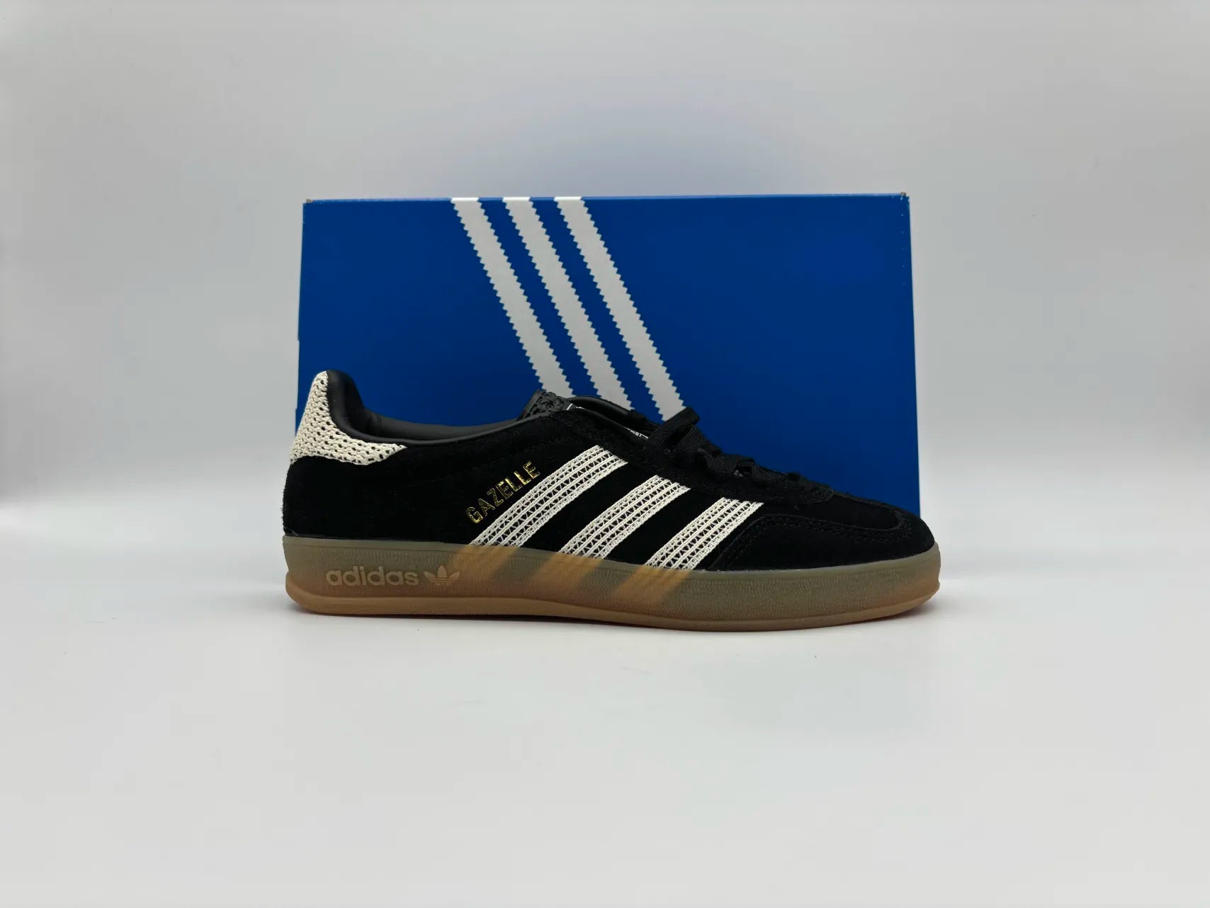 Side view of Adidas Gazelle Indoor Core Black Wonder White sneakers with classic low-top design, premium suede upper, and durable gum sole for indoor sports and casual wear

