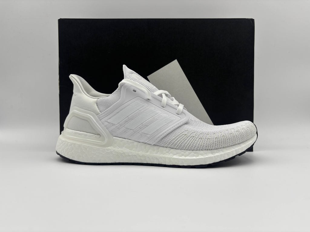 “Side view of Adidas Ultra Boost 20 Triple White running shoes with cushioned Boost midsole and sleek knit upper”