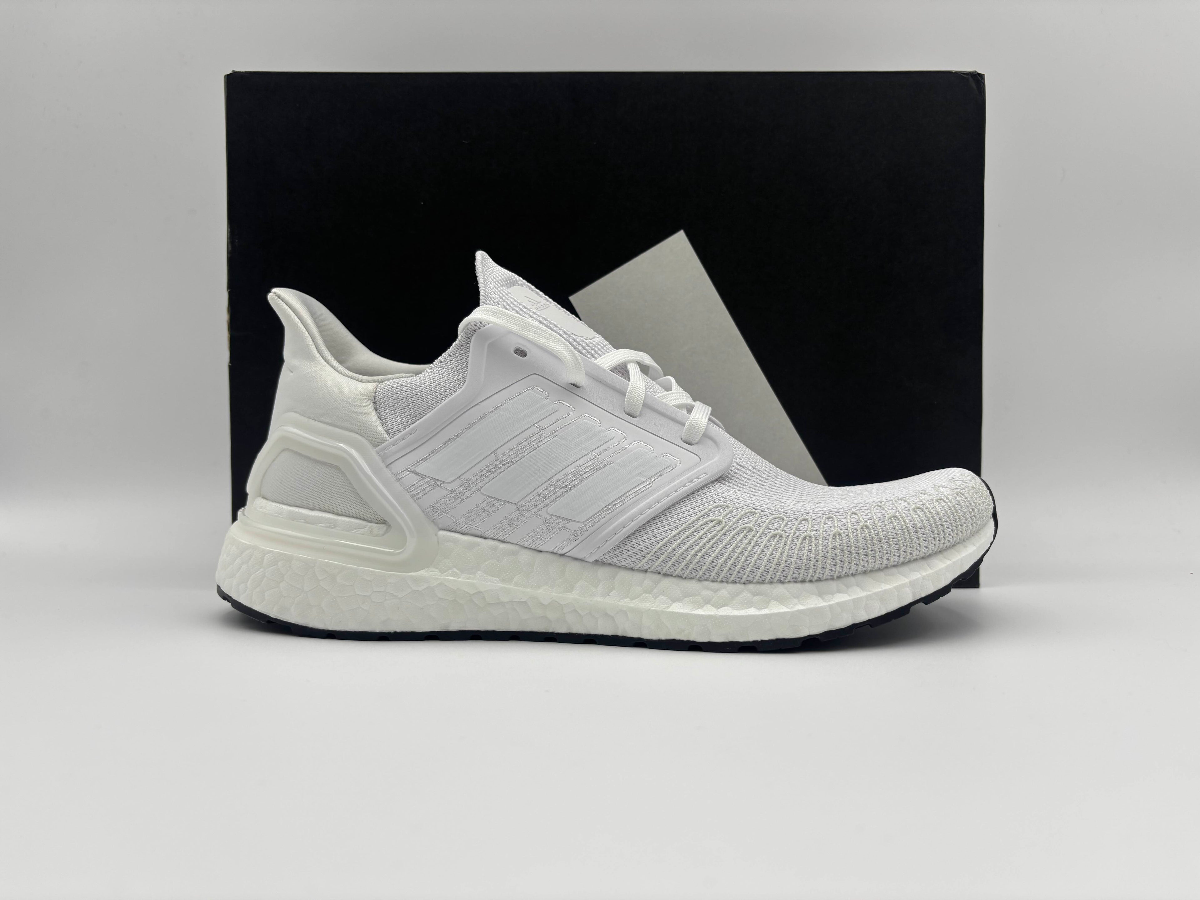 “Side view of Adidas Ultra Boost 20 Triple White running shoes with cushioned Boost midsole and sleek knit upper”