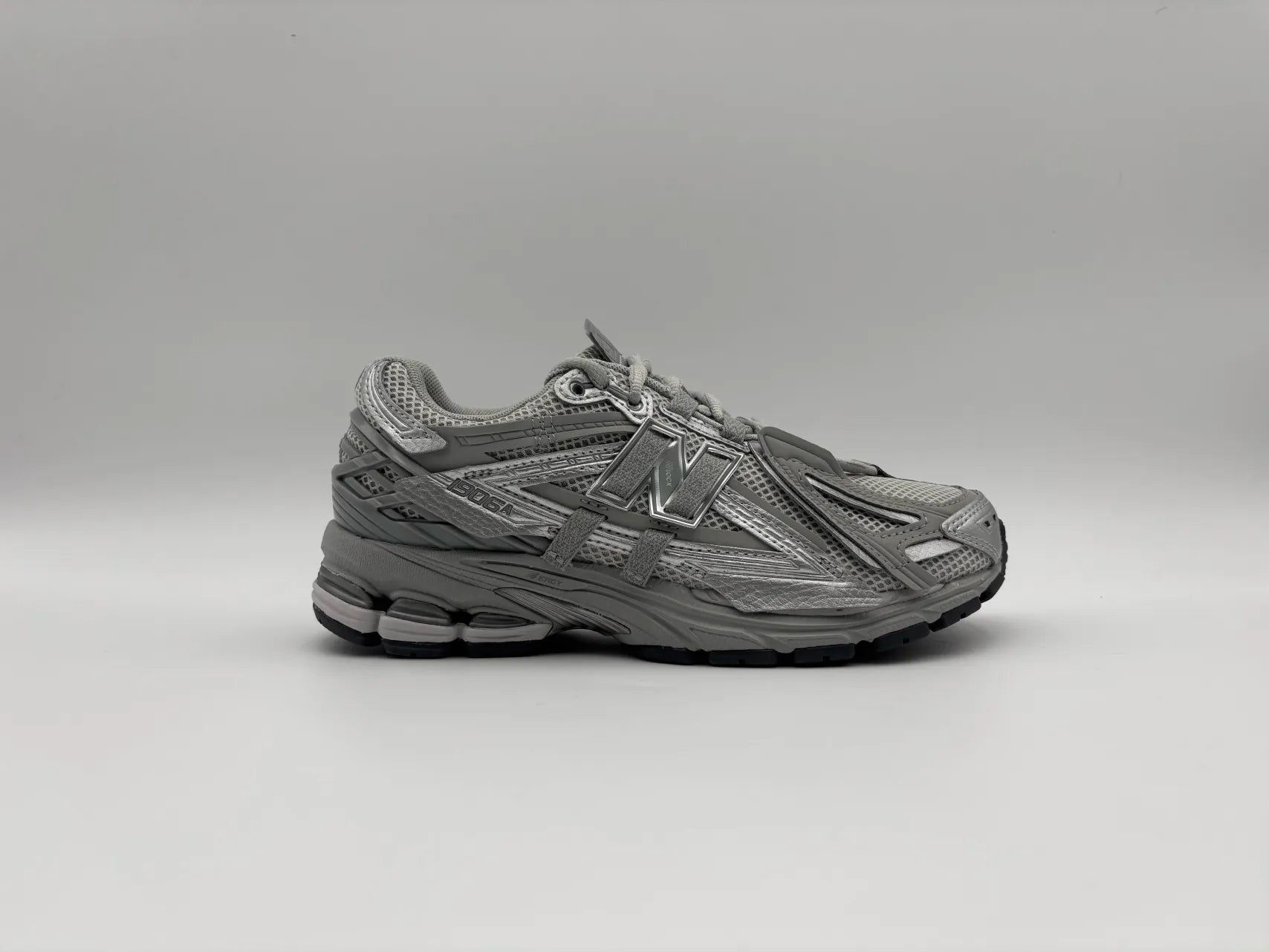 Side view of New Balance 1906A Tech Explosion Grey sneakers with retro-inspired design, mixed-material upper, and cushioned sole for casual wear and streetwear style
